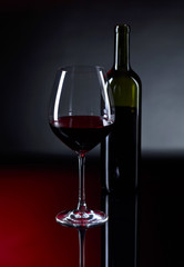 Glass and bottle of red wine.