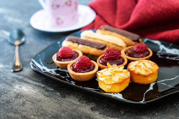Mixed dessert Raspberry tartlet, Eclair Puffs, almond lemon