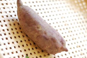 Raw sweet potato isolated on bamboo mat.