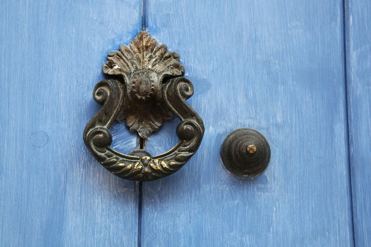 Traditional ornate door handle or knocker against a blue painted wooden door, Cartagena, Colombia.