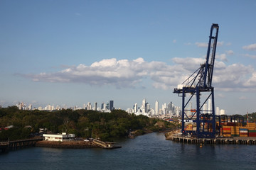 Fototapeta na wymiar Cargo port with crane & shipping containers along the entrance to the Panama Canal, with Panama city in the background.
