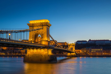Obraz premium Budapest, Hungary - Illuminated Szechenyi Chain Bridge over River Danube and Buda Castle Royal Palace at blue hour with clear blue sky
