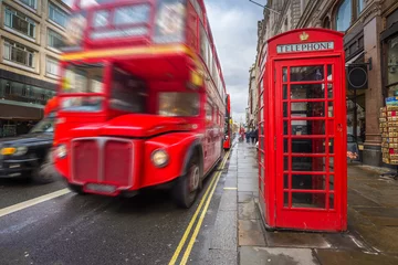 Fotobehang London, England - Iconic blurred black londoner taxi and vintage red double-decker bus on the move with traditional red telephone box in the center of London at daytime © zgphotography