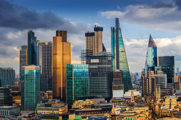 London, England - Panoramic skyline view of Bank and Canary Wharf, central London's leading financial districts with famous skyscrapers and other landmarks at golden hour sunset with blue sky