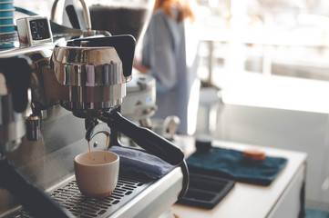 The coffee machine makes espresso, which flows into the Cup. On the background of the window.