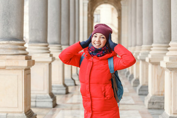 Woman tourist posing among columns in colonnade in Karlovy Vary, Czech Republic