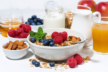 healthy breakfast. granola, fresh berries and fruits on white table