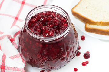 jar of cranberry jam on a white table, top view