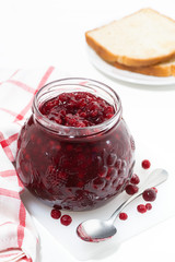 jar of cranberry jam on a white table, vertical top view