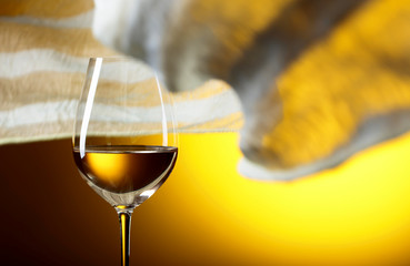 Glass of white wine on a yellow background.