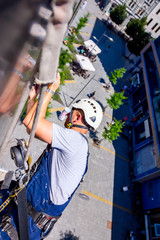 Industrial climber is washing, cleaning facade of a modern office building