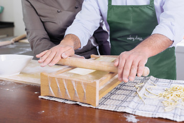 Man learning to do spaghetti alla chitarra fresh pasta during Italian cooking class
