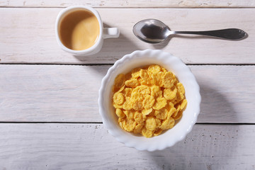 Corn Flakes cereal in a bowl and cap with espresso coffee. Morning breakfast.
