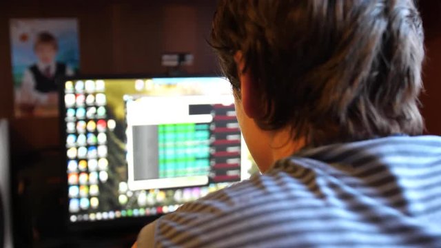 A young software engineer guy works in his office on a computer. Writes code for the program