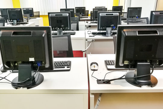 Empty Computer Classroom With Monitors On Top Of Table