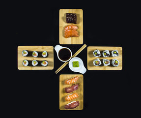 Sushi Set Composition on Bamboo plate with Sushi Rolls and Wasabi on Black Background