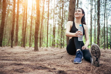 Asian girl is exercising at the weekend in a pine forest green and lush beautiful. Sport girl and lifestyle concept.