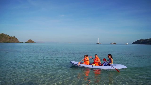 Happy family enjoying holiday by kayaking togehter at Labu Bajo beach, East Nusa Tenggara near Bali, Indonesia