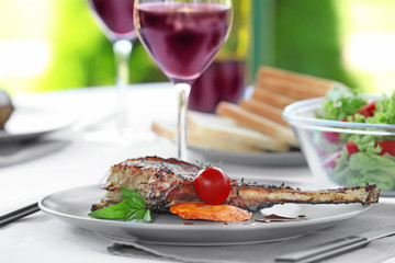 Plate with delicious rib and vegetables on table