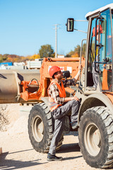 Wheel loader with tip-up bucket on construction site in action 
