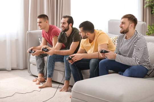 Young men playing video games at home