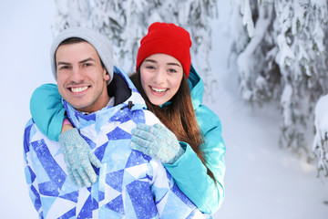Happy couple at beautiful snowy resort. Winter vacation