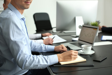 Man working at table in office, closeup. Forex concept