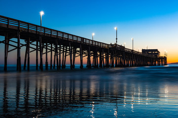 Naklejka premium California Złoty zachód słońca na molo plaży w Newport