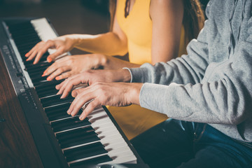 Piano players playing together four-handed piece during music school rehearsal 