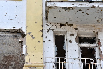Destroyed building after shelling in the war, bullet marks on the wall