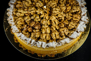 homemade almond coated tart on black background