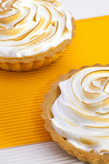 Two lemon tartalets on the white desk