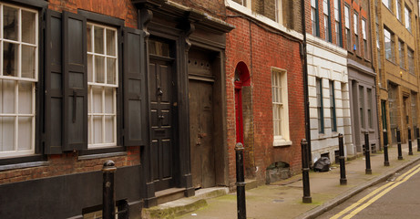 Naklejka premium Typowy rząd domów z ceglaną fasadą w bocznej uliczce Brik Lane w londyńskiej dzielnicy East End