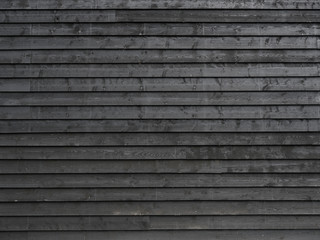 horizontal part of black painted wooden planks of barn wall or shed