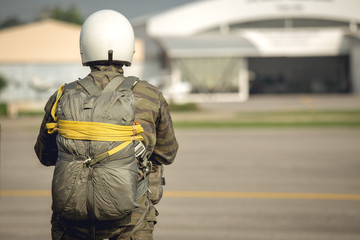 tactical paratrooper in camouflage uniform with T-10 parachute standby at airfield
