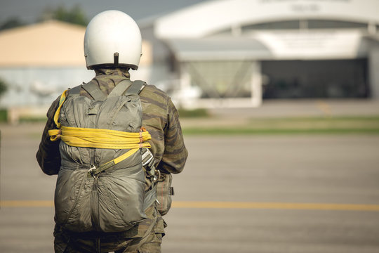 tactical paratrooper in camouflage uniform with T-10 parachute standby at airfield