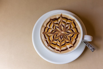 Latte art coffee cup on leather table, Top view