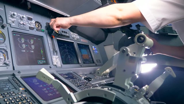 One airman switches a lever in a cockpit, close up.