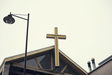 Detalle de cruz amarilla en la fachada de un lugar de culto
