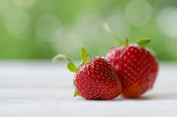 two strawberries on a wooden table