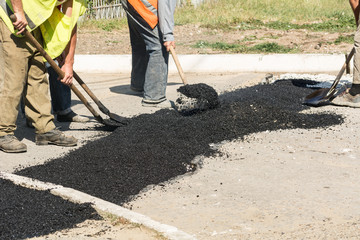 Road repair details. Workers fall asleep with hot asphalt pits on the road.