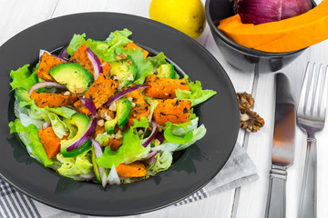 Delicious salad with avocado, pumpkin, greens