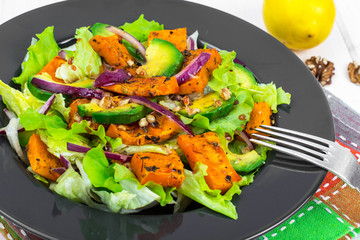 Delicious salad with avocado, pumpkin, greens