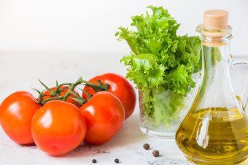 Olive oil, green salad lettuce and fresh tomato