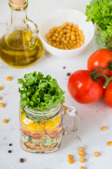 Salad in a jar. Homemade healthy salad from chickpea, tomato, yellow paprika, cucumber and green lettuce