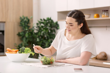 Best food. Upset concentrated woman looking down and tasting salad