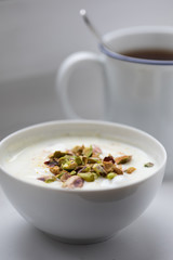 Joghurt mit Pistazien zum Frühstück mit Becher Ceylon Assam Tee