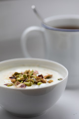 Joghurt mit Pistazien zum Frühstück mit Becher Ceylon Assam Tee