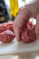 Frau bei Zubereitung von Hackbällchen aus Schwein und Rind in Küche