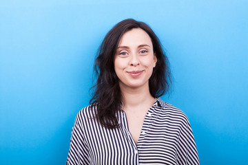 Fototapeta premium Smiling girl on blue background in studio photo